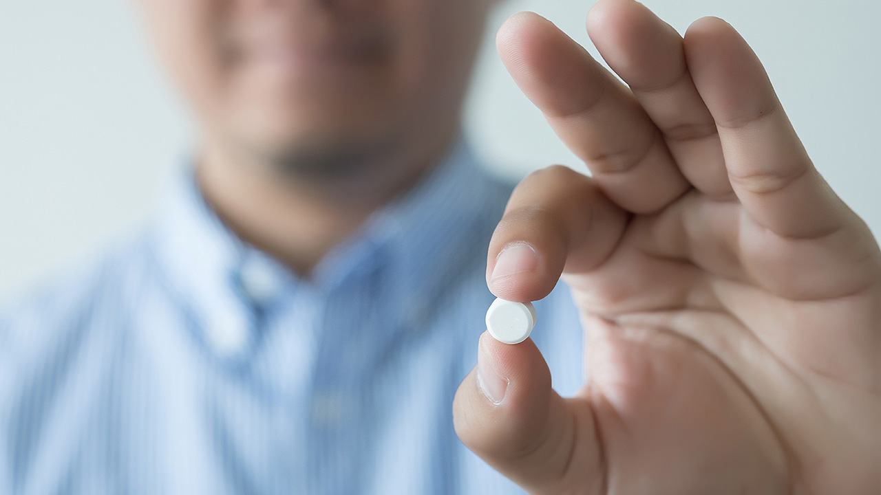 Man holds white pill