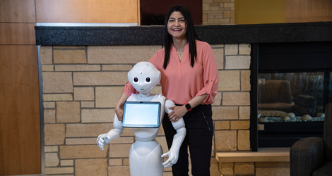Arishia Khan stand besides her robot