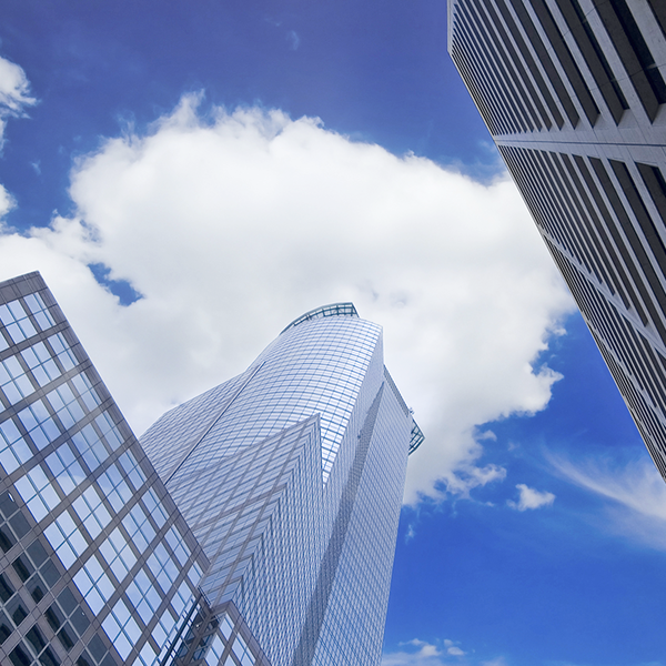 View of towering commercial buildings reaching up toward a blue sky